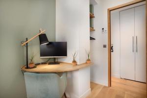 a desk with a computer on top of it in a room at Appartement standing -T3- Centre in Écully