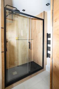 y baño con ducha y puerta de cristal. en Appartement standing -T3- Centre, en Écully