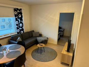 een woonkamer met een bank en een tafel bij Rovaniemi Cityapartment in Rovaniemi