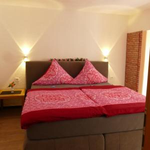 a bedroom with a bed with pink sheets and pillows at Ferienhaus "Einfach wohnen" in Beilstein