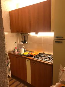 uma cozinha com armários de madeira e um forno com placa de fogão em Villa Respiro em Lampedusa