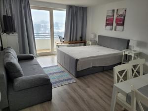 een slaapkamer met een bed, een bank en een tafel bij Haus Bergland in Neureichenau