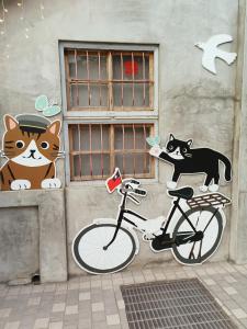 a painting of a cat and a bicycle on a wall at Fun Kaohsiung Backpacker Hostel in Kaohsiung