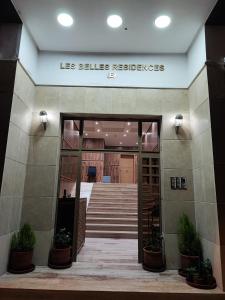 une entrée dans un bâtiment avec un panneau indiquant les preuves dans l'établissement Les Belles Residences E, à Tanger