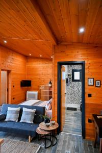 ein Schlafzimmer mit einem Bett und einem blauen Sofa in der Unterkunft VB ECO SUITES in Preveza