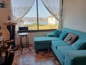 a living room with a blue couch and a large window at MarAzul in Valparaíso
