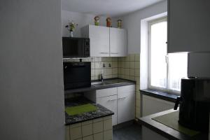 uma cozinha com um lavatório e um micro-ondas em Ferienhaus "Einfach wohnen" em Beilstein