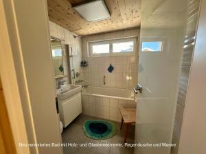 a bathroom with a tub and a sink and a toilet at Chasa Stefania mit rundum Bergblick und Garten in Scuol