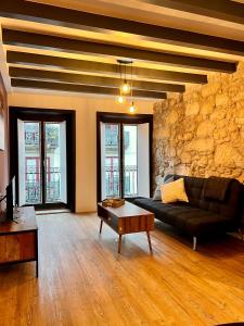 ein Wohnzimmer mit einem Sofa und einer Steinmauer in der Unterkunft A Muralha in Porto
