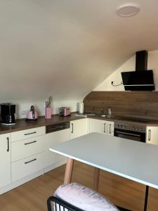 uma cozinha com armários brancos e uma mesa branca em Feriendomizile Menholz em Balingen