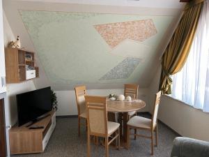 Elle comprend un petit salon avec une table et une télévision. dans l'établissement Ferienhaus Berndt im Spreewald, à Lübbenau