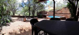 eine Terrasse mit Tisch und Swimmingpool in der Unterkunft Kiburi Cottage @ Kruger in Marloth Park
