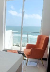 - une chambre avec un lit, une chaise et une fenêtre dans l'établissement Green Star City Apartment, à Dehiwala