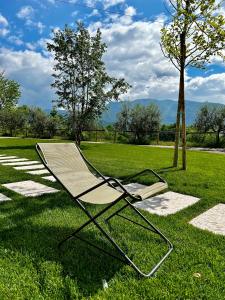 une chaise assise sur l'herbe dans un champ dans l'établissement Agriturismo Ca' Cristane, à Rivoli Veronese