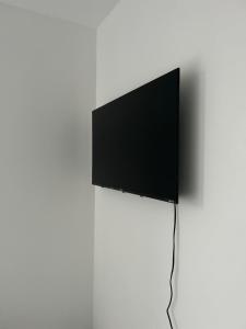 TV de pantalla plana en una pared blanca en A&K Inn, en Bournemouth
