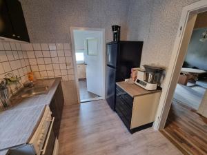 eine Küche mit einem schwarzen Kühlschrank und einer Spüle in der Unterkunft Ferienwohnung Plötzky in Plötzky