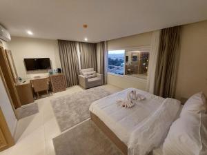 カイロにあるDouDou Pyramids View Hotelのベッドと大きな窓が備わるホテルルームです。