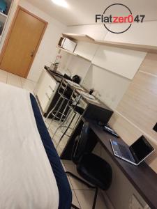 - une chambre avec un lit et un bureau avec un ordinateur portable dans l'établissement Flatzer047 Executivo, à Caxias do Sul