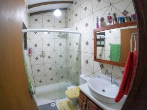 a bathroom with a sink and a toilet and a mirror at Casa Reino in Ilhabela