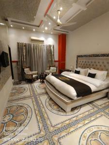 Grand AlFateh Hotel في لاهور: غرفة نوم بسرير كبير وسجادة كبيرة
