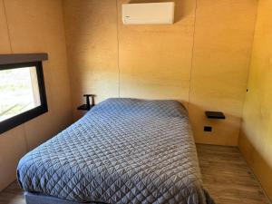 Habitación pequeña con cama y ventana en Casa a pasos de la playa, en Punta del Este