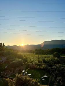 una puesta de sol sobre un campo con las montañas en el fondo en Agriturismo Ca' Cristane, en Rivoli Veronese