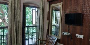 a room with two windows and a television on the wall at OSAHAN PARADISE HOMESTAY NEAR Golden temple and park view in Amritsar