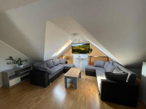 a living room with a couch and a tv at NikoLux Apartman in Hajdúszoboszló