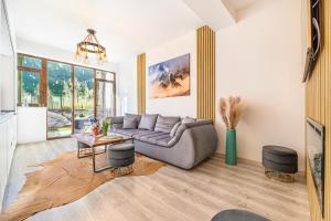a living room with a couch and a table at Ama Garden Apartment Busteni in Buşteni