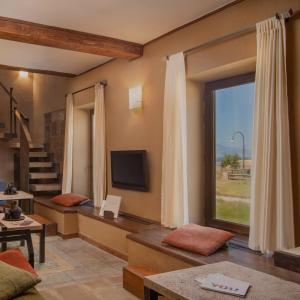 a living room with a large window and a television at Tufenkian Avan Marak Tsapatagh Hotel in Kzylkʼend