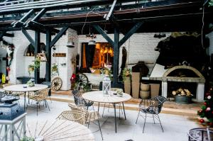 un patio con mesas y sillas y una chimenea en Breza Hotel Borovets en Borovets