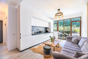 a living room with a couch and a table at Ama Garden Apartment Busteni in Buşteni
