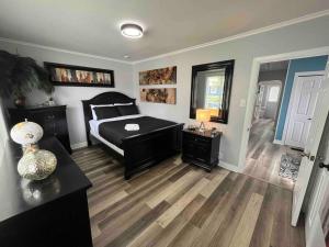 una camera con letto e pavimento in legno di Maple Blue a St. John's
