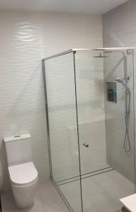 a white bathroom with a shower and a toilet at ARay at Cooee Bay - Apt B - Beach House Yeppoon in Yeppoon
