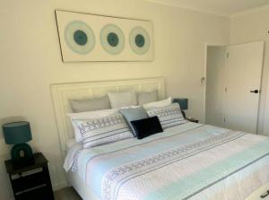 a bedroom with a large white bed with pillows at ARay at Cooee Bay - Apt B - Beach House Yeppoon in Yeppoon