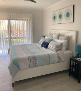 a bedroom with a large bed with pillows on it at ARay at Cooee Bay - Apt B - Beach House Yeppoon in Yeppoon