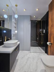 a bathroom with a sink and a shower at Aurum Apartamenty Nowy Sącz Aleje Piłsudskiego 20 Bezpłatny parking! in Nowy Sącz