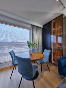 a dining room with a table and chairs and a large window at Aurum Apartamenty Nowy Sącz Aleje Piłsudskiego 20 Bezpłatny parking! in Nowy Sącz
