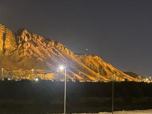 a mountain lit up at night with street lights at شقق ايلاف طيبة in Al Madinah