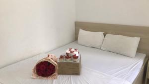 ciasto i róże siedzące na łóżku w obiekcie Hotel Ngọc Phụng w mieście Ban Blech