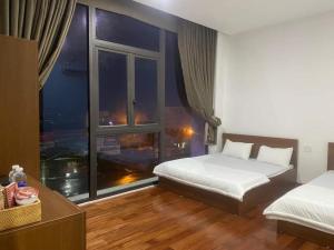 sypialnia z 2 łóżkami i dużym oknem w obiekcie Hotel Ngọc Phụng w mieście Ban Blech