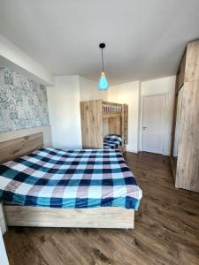 a bedroom with a bed with a blue and white checkered blanket at Cozy Apartment 201A • BMIX • in Bakuriani