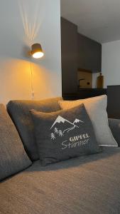 a couch with a pillow with a mountain on it at kleineauszeit3, Feldberg, direkt an Skipiste, mit Sauna in Feldberg