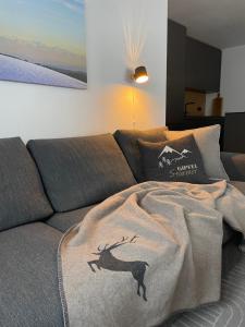 uma sala de estar com um sofá com um cobertor em kleineauszeit3, Feldberg, direkt an Skipiste, mit Sauna em Feldberg