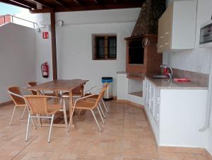 een keuken met een houten tafel en stoelen bij Estancia Cecilia in La Orotava