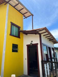 a yellow and white house with a wooden door at Pousada Sesmaria in Lavras Novas