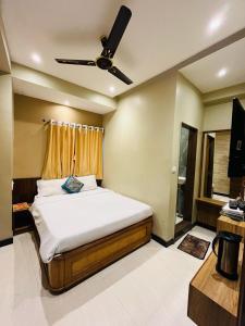 a bedroom with a bed with a ceiling fan at Hotel Starlight in Mount Ābu