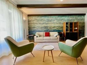 Una sala de estar con dos sillas y un sofá. en Deluxe Apartment Vittorio Po Torino centro, en Turín