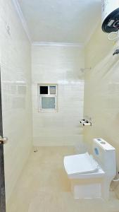 uma casa de banho branca com um WC e uma janela em Hotel Relax In - Noida Sector 18 em Noida