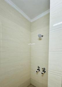 a shower with two faucets in a bathroom at Hotel Relax In - Noida Sector 18 in Noida